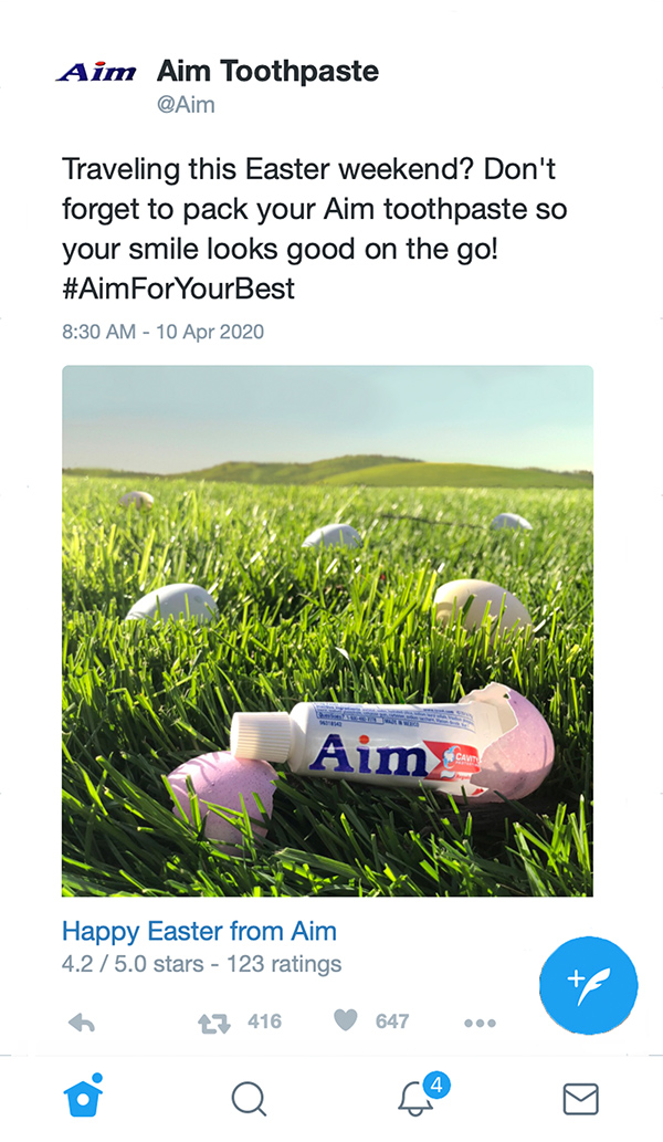 Image of mockup for a Twitter advertisement promoting AIM toothpaste by Kirsten DeZeeuw. Shows small toothpaste tube sitting near easter eggs on grass.