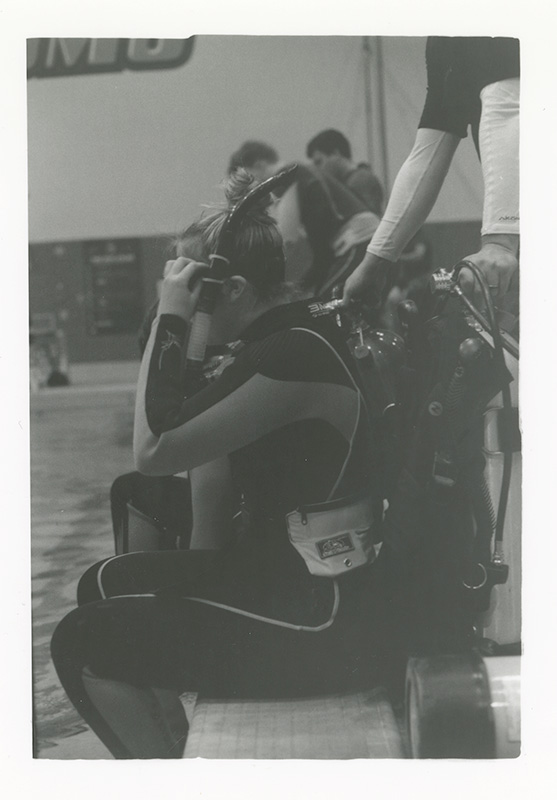 Film photograph of diver entering water from seated position. Photo by Kirsten DeZeeuw