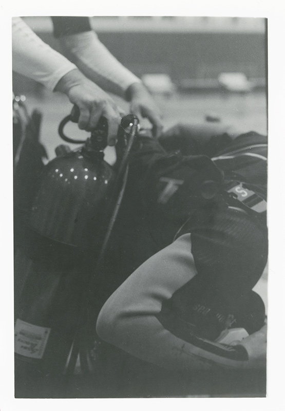 Close up photo of someone putting on their boyancy control device. Photo by Kirsten DeZeeuw